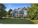 Charming two-story home with blue siding, stone accents, manicured lawn, and mature trees at 1210 Magnolia Park Cir, Cumming, GA 30040