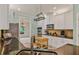 Traditional kitchen with white cabinets, black countertops, stainless steel appliances, and a decorative hanging pot rack at 1210 Magnolia Park Cir, Cumming, GA 30040