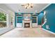 Bright living room featuring a fireplace, built-in shelves, and large windows at 1210 Magnolia Park Cir, Cumming, GA 30040