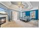 The spacious main bedroom features a tray ceiling, fireplace, and a doorway to the main bathroom at 1210 Magnolia Park Cir, Cumming, GA 30040