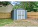 Backyard shed with double doors, offering practical storage solutions and a fenced perimeter at 1210 Magnolia Park Cir, Cumming, GA 30040