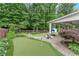 Landscaped backyard with a putting green, a patio, and a covered porch at 336 Parc Xing, Acworth, GA 30102