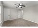 Spacious bedroom with neutral carpet, ceiling fan, and two entry doors at 336 Parc Xing, Acworth, GA 30102