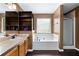 Bright bathroom featuring double sinks, a bathtub, a shower and built in wooden shelving at 966 Crest Ridge Sw Dr, Marietta, GA 30060