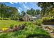Expansive backyard with lush greenery leading to outdoor entertaining area, perfect for relaxation and gatherings at 11355 Bowen Rd, Roswell, GA 30075