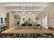 Open dining room with wooden table, designer lighting, and adjacent living area featuring a brick fireplace at 11355 Bowen Rd, Roswell, GA 30075