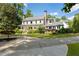 Attractive two-story home with a covered front porch, enhanced by mature trees and manicured greenery at 11355 Bowen Rd, Roswell, GA 30075