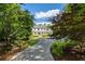 Serene two-story home with a covered porch surrounded by mature trees and beautifully landscaped grounds at 11355 Bowen Rd, Roswell, GA 30075