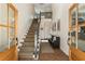 Bright foyer with brick floor, wooden staircase and a charming bench with framed prints at 11355 Bowen Rd, Roswell, GA 30075