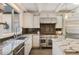 Well-lit kitchen with stainless steel appliances, white cabinets, granite countertops, and a tile backsplash at 11355 Bowen Rd, Roswell, GA 30075