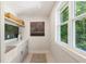 This modern laundry features bright white cabinets, open shelving, and a window with natural light at 11355 Bowen Rd, Roswell, GA 30075