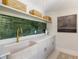 The modern laundry room offers a unique basin sink, green tile backsplash, and ample storage at 11355 Bowen Rd, Roswell, GA 30075