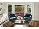 Cozy sitting area features two armchairs, ottomans, and large windows with scenic outdoor views at 11355 Bowen Rd, Roswell, GA 30075