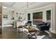 Bright living room with dark floors, beamed ceilings, and large windows overlooking lush greenery at 11355 Bowen Rd, Roswell, GA 30075