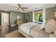 This primary bedroom features a ceiling fan, neutral decor, and a window with backyard views at 11355 Bowen Rd, Roswell, GA 30075