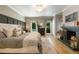 Comfortable main bedroom with fireplace, wood floors, and scenic views from multiple windows at 11355 Bowen Rd, Roswell, GA 30075