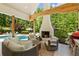 Inviting covered patio featuring a cozy fireplace, comfortable seating, and a view of the pool at 11355 Bowen Rd, Roswell, GA 30075