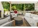 Inviting covered outdoor living area with fireplace, outdoor kitchen, bar seating and comfortable seating arrangement at 11355 Bowen Rd, Roswell, GA 30075
