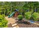 Backyard playground with a slide and swings offers fun for amid a beautiful, wooded setting at 11355 Bowen Rd, Roswell, GA 30075