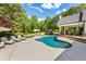 A beautifully landscaped backyard with a built-in pool and covered patio with an outdoor kitchen and dining area at 11355 Bowen Rd, Roswell, GA 30075