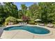 Inviting in-ground pool with lounge chairs, an outdoor kitchen, and beautiful backyard landscaping at 11355 Bowen Rd, Roswell, GA 30075
