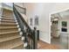 Staircase with hardwood steps, dark wood railing, and access to living room at 11355 Bowen Rd, Roswell, GA 30075