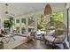 Inviting sunroom with wicker chair, large windows with a view to the pool, and bright natural light at 11355 Bowen Rd, Roswell, GA 30075
