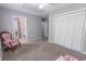 Carpeted bedroom with gray walls, two closets, and two accent chairs; bathroom and hallway in view at 1731 Pryor Sw Rd # 109, Atlanta, GA 30315