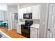 Bright kitchen featuring white cabinets, black appliances, open layout, and view of laundry area at 1731 Pryor Sw Rd # 109, Atlanta, GA 30315
