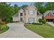 Stunning two-story home with a long driveway, manicured lawn, and charming architectural details at 4735 Cambridge Trce, Atlanta, GA 30338