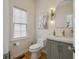 Stylish powder room featuring modern fixtures, arched mirror, and an artistic cactus print at 4735 Cambridge Trce, Atlanta, GA 30338