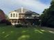 Back of house featuring multi-level deck, screened porch, and stairs leading to green lawn, nestled in mature trees at 4735 Cambridge Trce, Atlanta, GA 30338