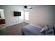 Comfortable bedroom with a mounted TV, ceiling fan, and soft carpet, bathed in natural light at 760 King Sword Ct, Mableton, GA 30126