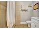 Bathroom with a shower curtain, toilet, vanity, light, and decorations on floating shelves at 78 Atlanta Se Ave, Atlanta, GA 30315