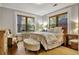 Bright bedroom with two windows, neutral walls, hardwood floors, and an ottoman at the foot of the bed at 78 Atlanta Se Ave, Atlanta, GA 30315