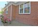 Side view of a brick home with white trim and a pot of blooming pink flowers at 78 Atlanta Se Ave, Atlanta, GA 30315