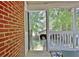 Open and airy porch features red brick and views of the fenced in backyard and outbuilding at 78 Atlanta Se Ave, Atlanta, GA 30315