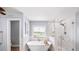 Bright bathroom with a luxurious soaking tub, walk-in glass shower, and a large window for natural light at 149 Manor Ln, Woodstock, GA 30188
