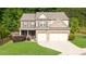 Beautiful two-story brick home with a well-manicured lawn and attached two-car garage at 149 Manor Ln, Woodstock, GA 30188