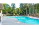 Community pool surrounded by mature trees and a spacious sun deck at 149 Manor Ln, Woodstock, GA 30188