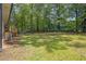 Expansive backyard with lush grass, mature trees, and a wooden deck perfect for outdoor entertaining at 2184 Cherokee Valley Cir, Lithonia, GA 30058