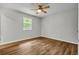 Bright bedroom features wood-look flooring, a ceiling fan, and a window providing natural light at 2184 Cherokee Valley Cir, Lithonia, GA 30058