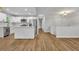 Open-concept kitchen with stainless steel appliances, white cabinetry, and hardwood flooring at 2184 Cherokee Valley Cir, Lithonia, GA 30058