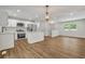 Open floor plan kitchen featuring stainless steel appliances, white cabinets, and hardwood floors at 2184 Cherokee Valley Cir, Lithonia, GA 30058