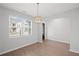 Open-concept dining area showcasing wood floors, a pendant light, and a view of the front yard at 3650 River Rock Rd, Lithonia, GA 30038