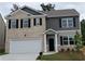 Charming two-story home with a brick facade, complemented by black shutters and a well-manicured front lawn at 3650 River Rock Rd, Lithonia, GA 30038