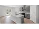 Modern kitchen features an island with quartz countertop, stainless steel appliances, and access to the backyard at 3650 River Rock Rd, Lithonia, GA 30038