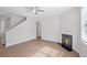 Spacious living room with a cozy fireplace, light wood floors, and a modern ceiling fan at 3650 River Rock Rd, Lithonia, GA 30038