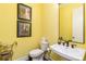 Cozy half-bathroom with yellow walls, pedestal sink, and modern faucet at 963 South On Main Dr, Woodstock, GA 30188