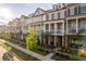 Charming townhomes featuring brick exteriors, covered porches, manicured lawns, and a welcoming neighborhood setting at 963 South On Main Dr, Woodstock, GA 30188